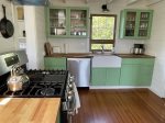 Kitchen area with large gas cooking range and brightly colored cabinets